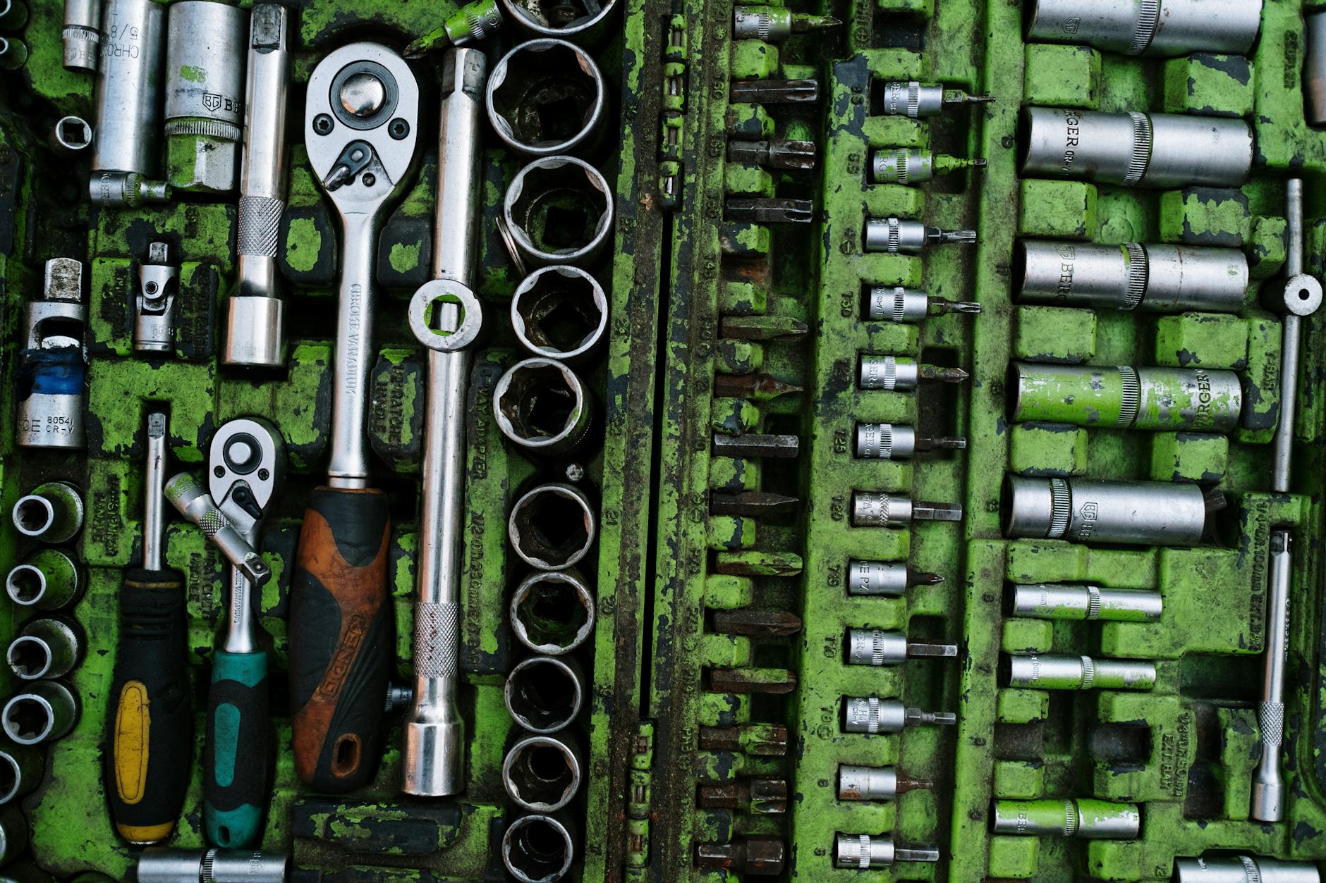 Industrial Tools: 3 Must-Have Safety Tips A well-organized set of metal tools in a green toolbox with ratchets and screwdrivers.