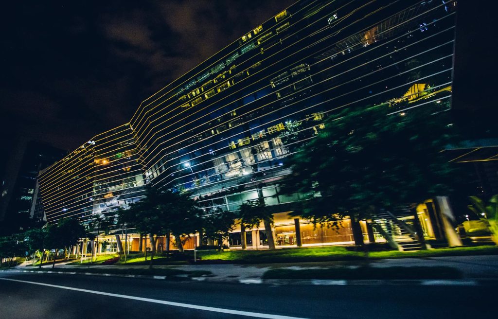 Corporate Office Relocation Made Effortless: 3 Pro Tips Blurred motion captures a modern building at night in an urban setting.
