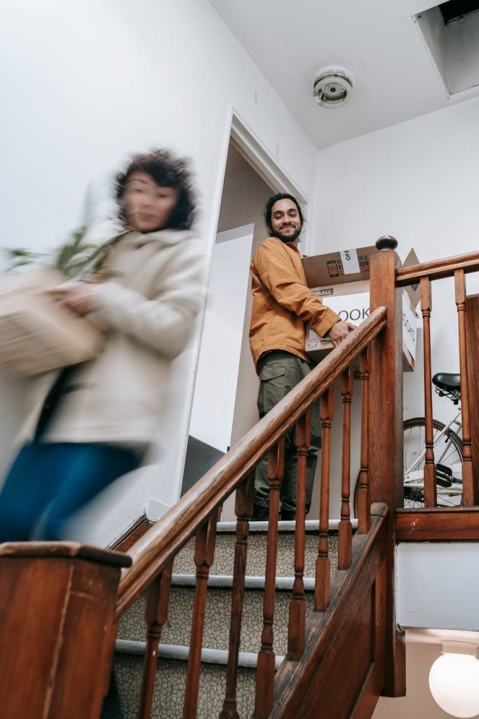 Relocation Furniture Salvage: Effortless 3-Step Guide A joyful couple moving into their new apartment, carrying boxes and plants upstairs.