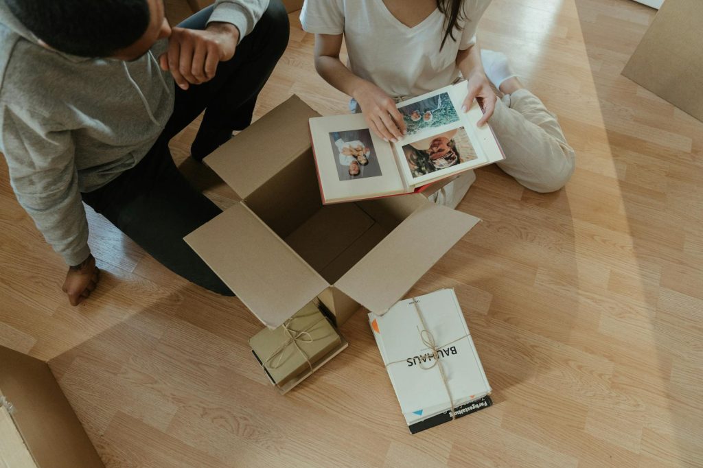 Sensitive Documents Packing Tips: Effortless Solutions for Your Move Couple going through photo albums while unpacking boxes in their new home.