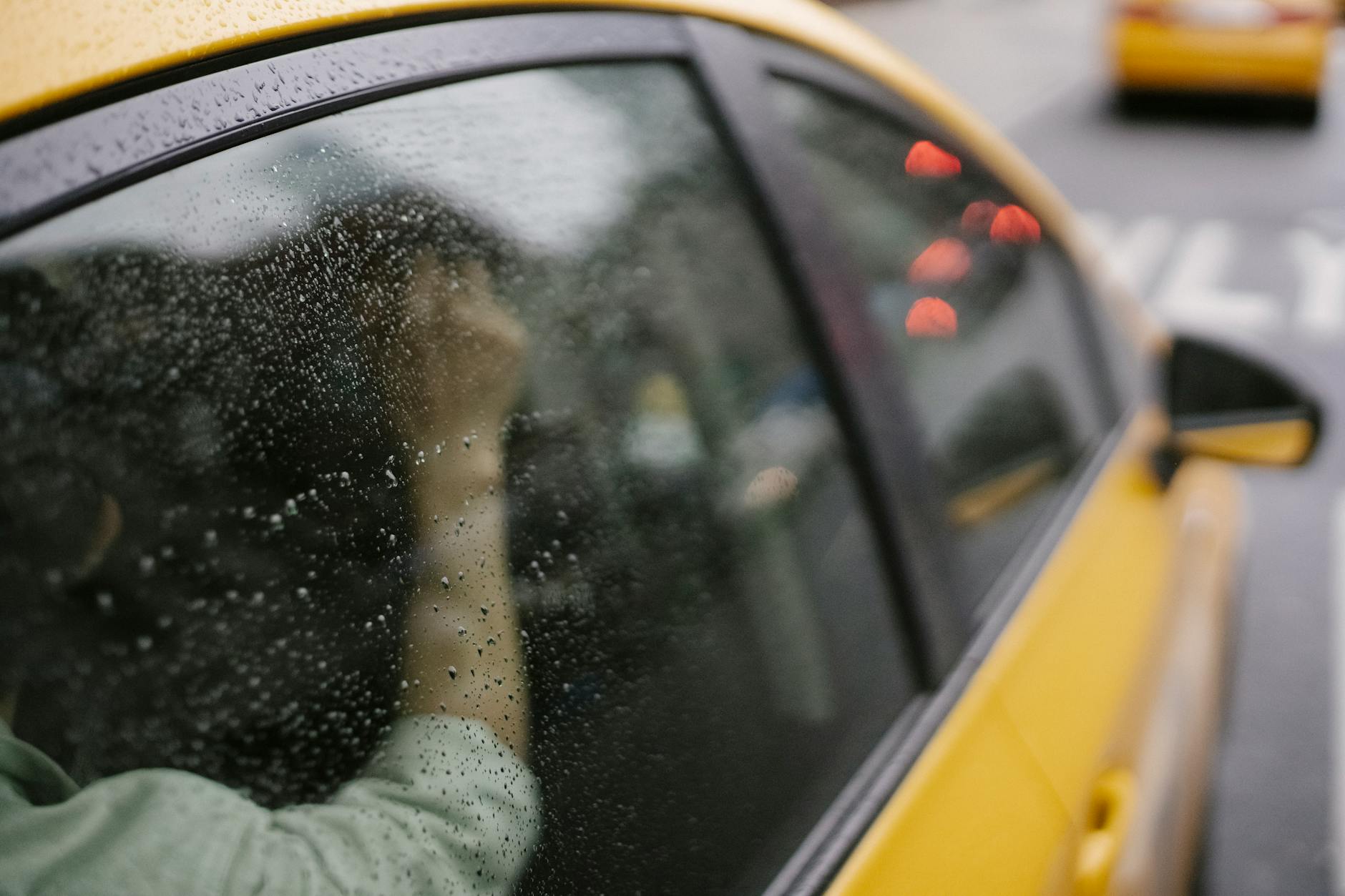 Car Transport Mistakes: Avoid These 4 Costly Errors Crop anonymous passenger sitting in yellow taxi car on road in town in rainy weather