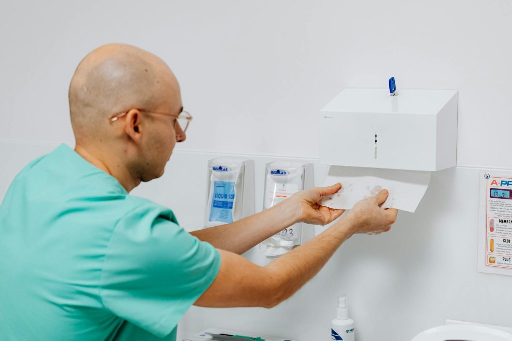 Moving Day Salvage Made Effortless: 4 Essential Tools Doctor using a hand towel dispenser in a clinical setting, emphasizing hygiene.