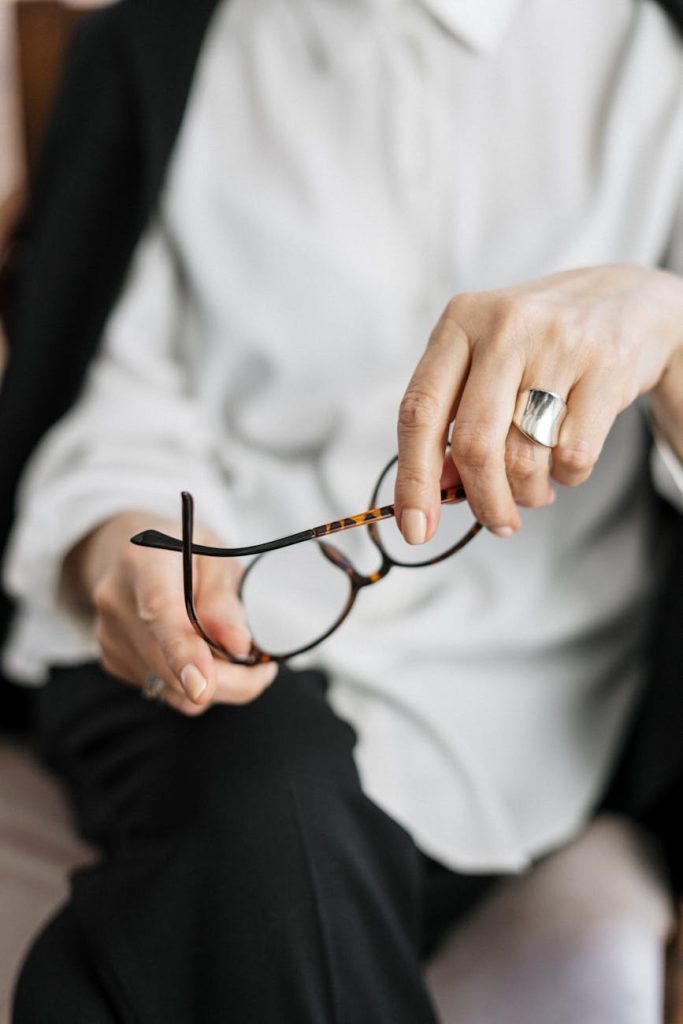 Office Relocation Made Effortless: 4 Expert Tips Close-up of a woman holding glasses, symbolizing thought and professionalism.