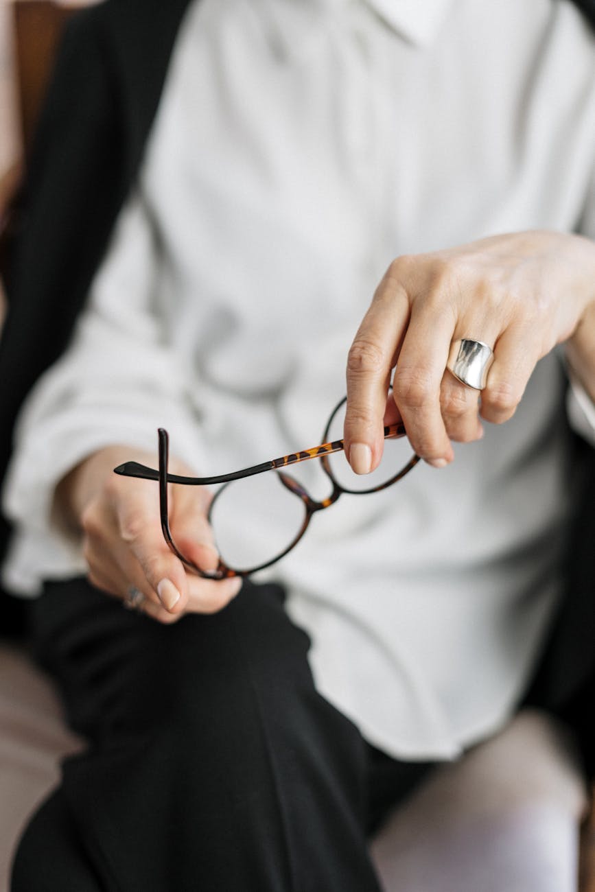 Office Relocation Made Effortless: 4 Expert Tips Close-up of a woman holding glasses, symbolizing thought and professionalism.