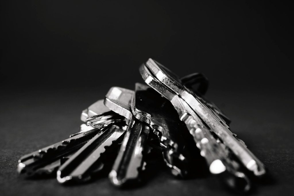 Industrial Removals Made Effortless: 4 Key Tips for Stress-Free Operations A close-up shot of a pile of metallic keys on a dark surface, emphasizing security and precision.