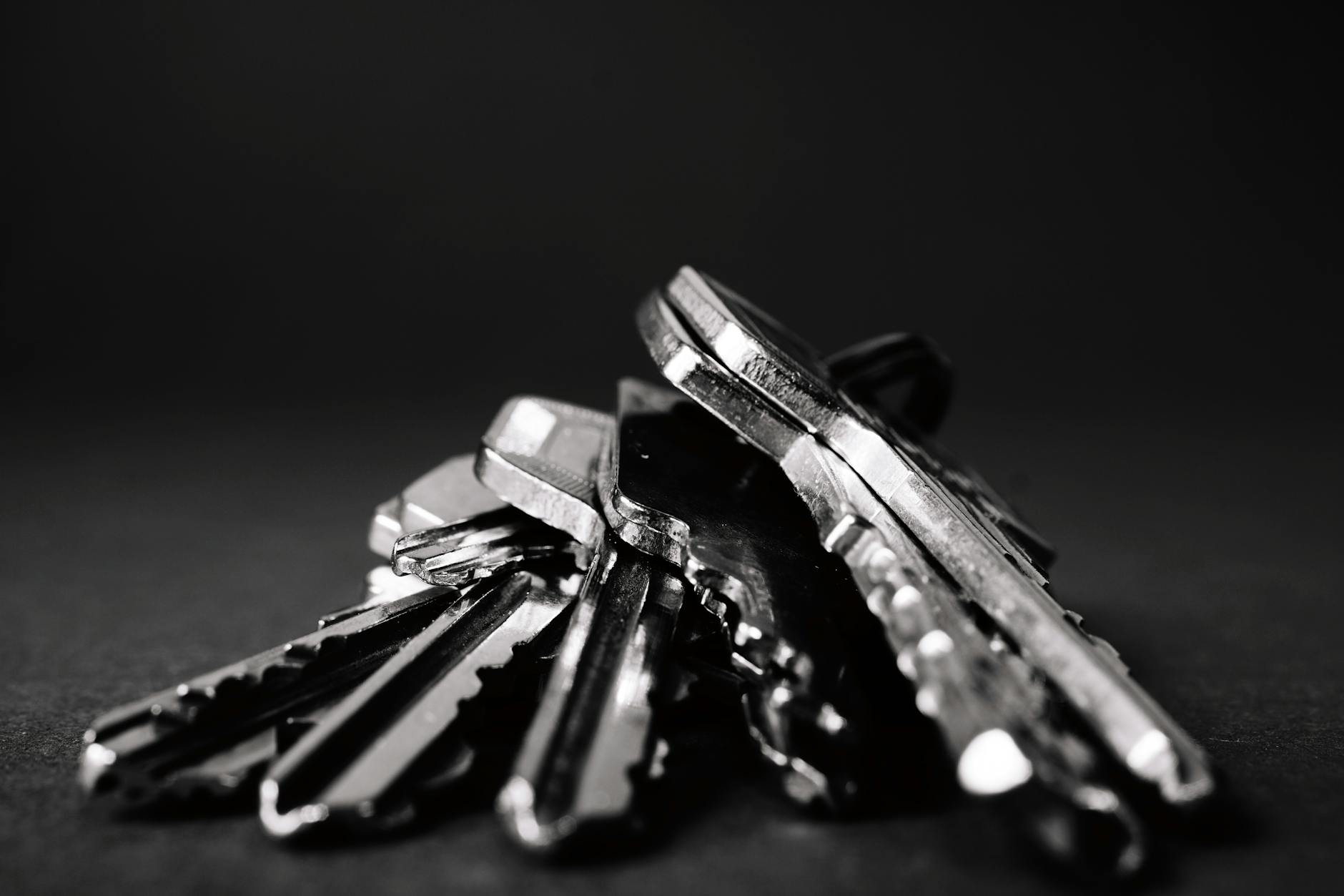 Industrial Removals Made Effortless: 4 Key Tips for Stress-Free Operations A close-up shot of a pile of metallic keys on a dark surface, emphasizing security and precision.
