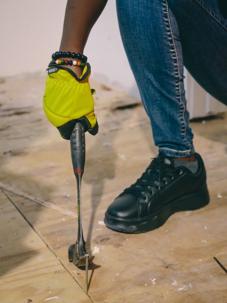 Industrial Removal: Must-Have Safety Checks for Effortless Efficiency A person with protective gloves using a claw tool to remove nails from a wooden board.