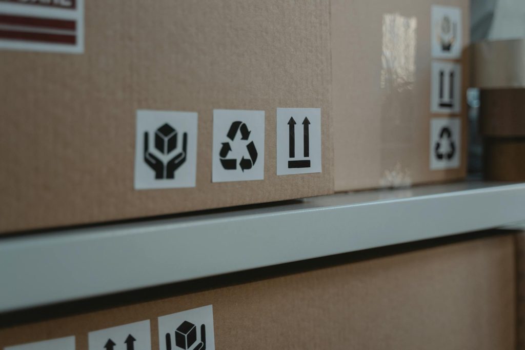 Commercial Move: Effortless Tips for Budget-Friendly Organization Close-up of cardboard boxes displaying shipping and recycling symbols, ideal for logistic themes.