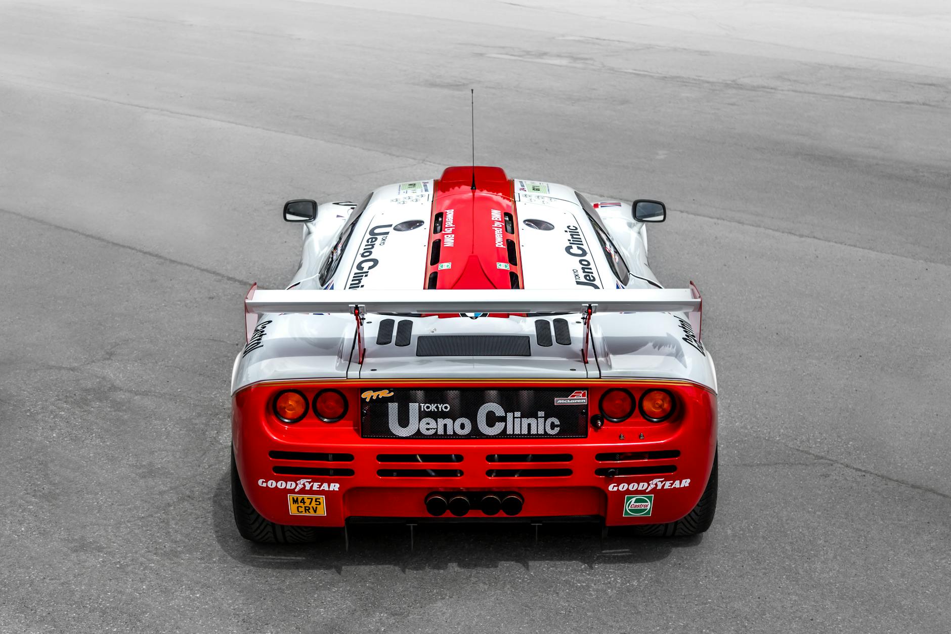 F1 Removals: Effortlessly Save Money on Car Transport Red and white race car captured from behind on an open track.