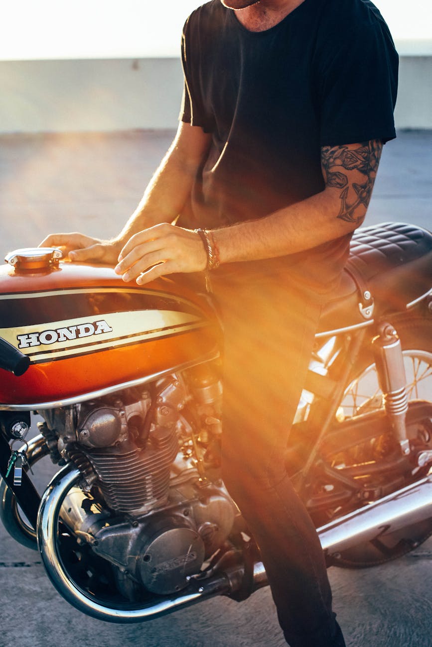 Motorcycle Transportation Made Effortless: 6 Must-Try Hacks Crop anonymous young tattooed male biker in casual clothes sitting on modern motorcycle on asphalt road on sunny day