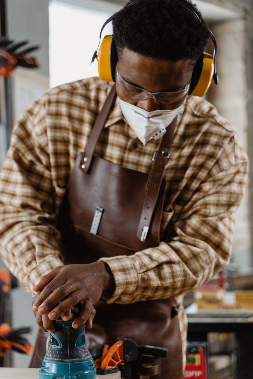 Industrial Moves Made Effortless: 6 Reasons to Hire F1 Removals Focused woodworker wearing protective gear while using a power sander in a workshop.