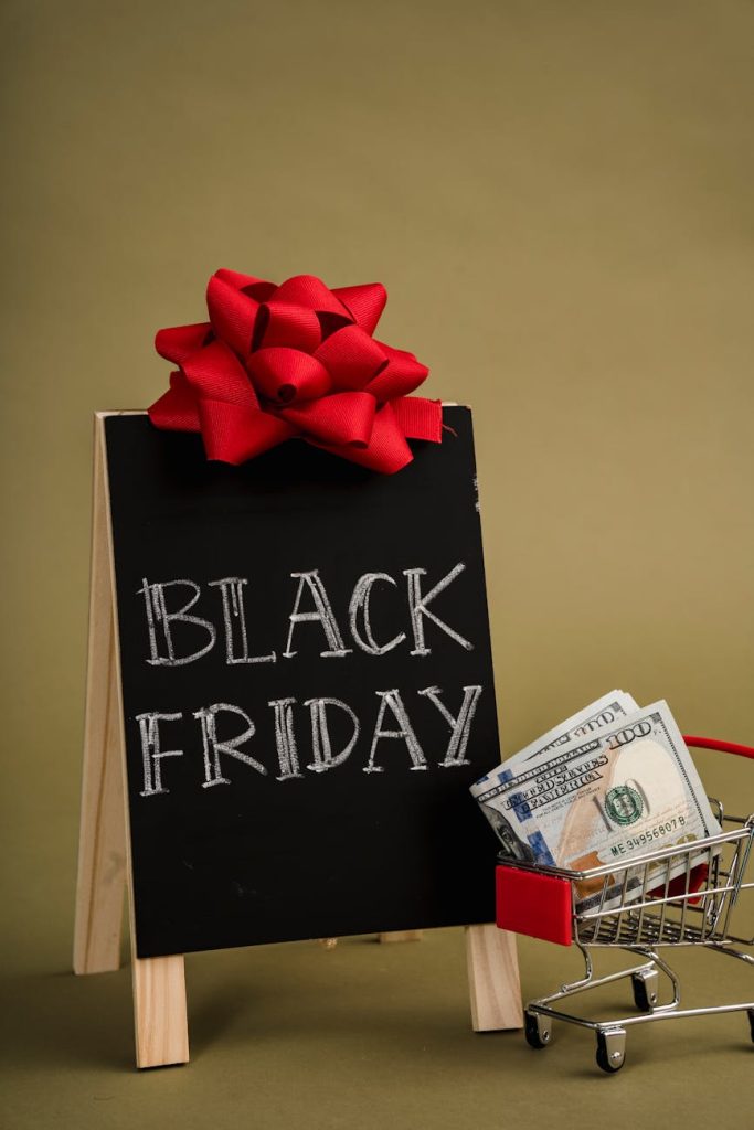 Salvaged Items: 6 Must-Have Secrets for Cash Profit A chalkboard sign with Black Friday written on it and a small shopping cart with dollar bills, ideal for sales promotions.