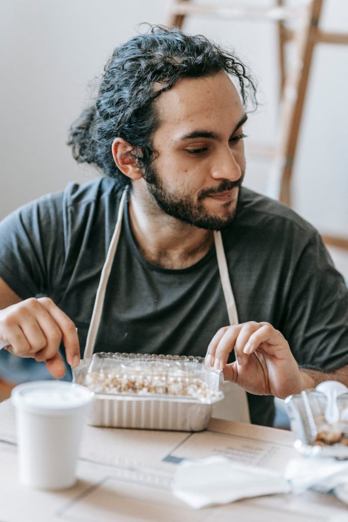 Fast Home Relocation: 6 Must-Have Strategies for Affordable Moving A man enjoys a takeout meal indoors, exuding a relaxed mood.