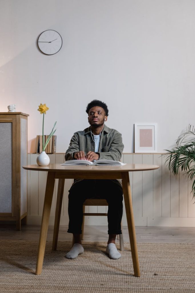 Effortless Office Furniture Moving: Expert Tips for Damage-Free Relocation A man attentively reads a braille book in a cozy, minimalist office space.