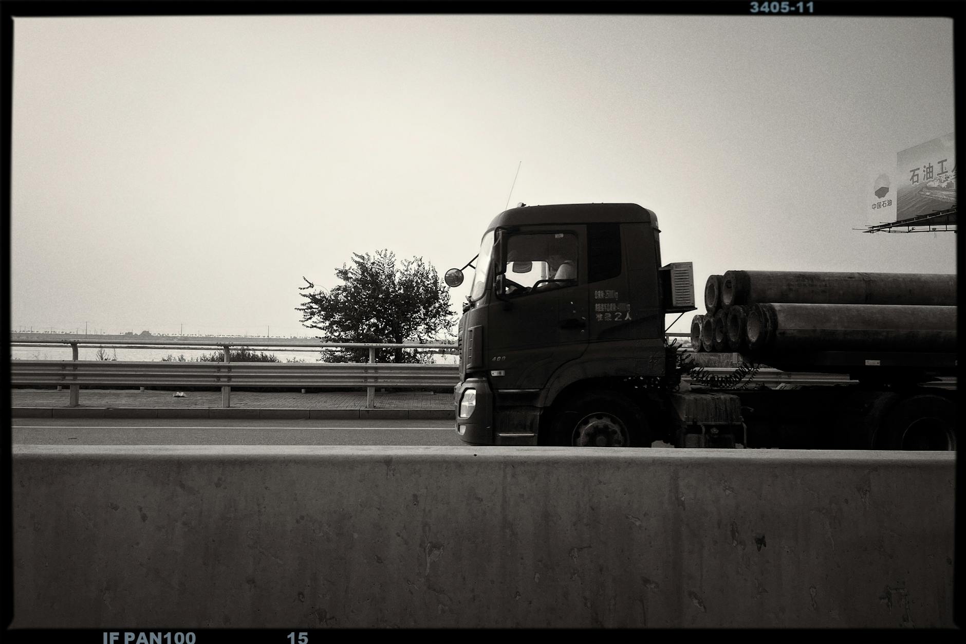 Car Transportation Made Effortless: Expert Tips for Long Distance Monochrome image of a truck carrying pipes on a highway, minimalistic and artistic.