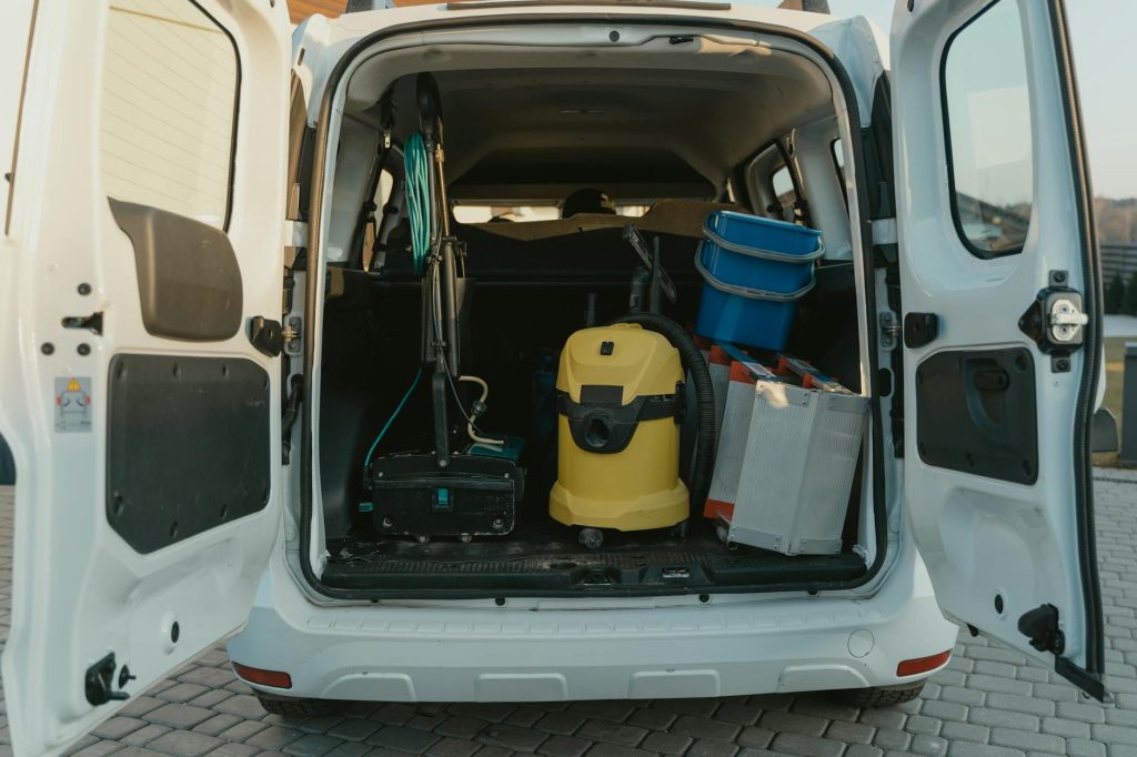 Save on International Car Transportation Costs: Effortless Tips for Budget-Friendly Shipping A van with cleaning supplies reveals its open trunk filled with tools and equipment.