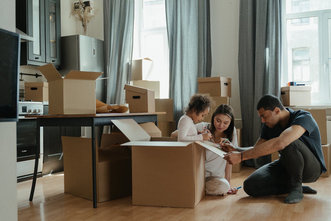 Home A family unpacks moving boxes in their new home kitchen, creating a cozy atmosphere.