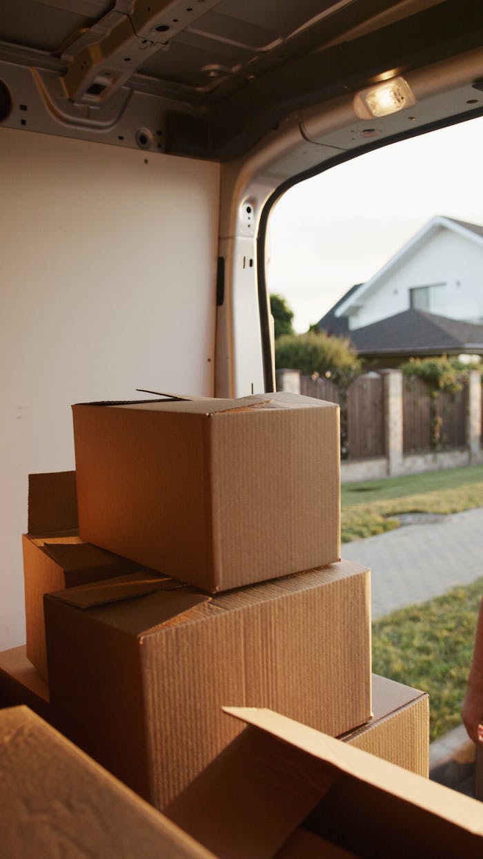 Home View inside a delivery van with stacked cardboard boxes ready for moving.